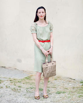 Elegantly Dressed Brunette Woman Holding A Handbag, Florence, Tuscany, Italy.
