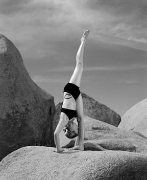 Woman Doing Yoga Outdoors On Boulders
