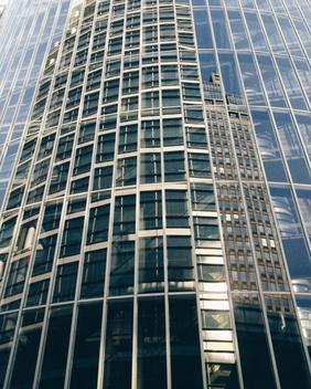 The Netherlands, Amsterdam, Office buildings reflecting in glass facade of modern apartments,