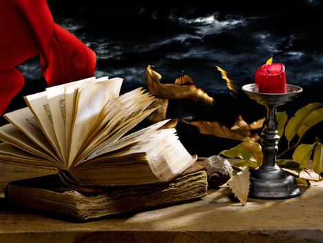 Still Life With Old Books And Candle, Flying Autumn Leaves And Red Curtain On Dark Wood And A Stormy Sky In The Background