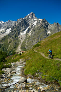 Man riding his mountain bike down a trail in the mountains.