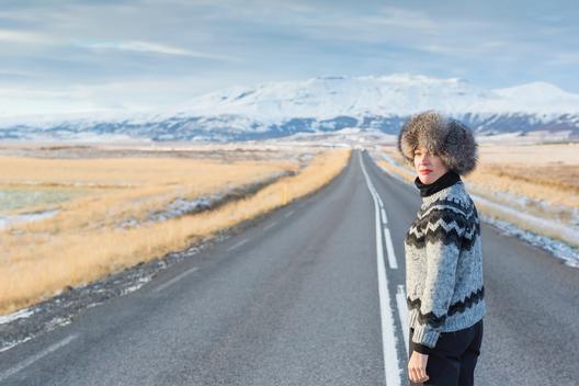 Mature woman standing in middle of country road, Iceland