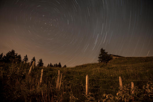 star trails and polaris with farm and house in foreground