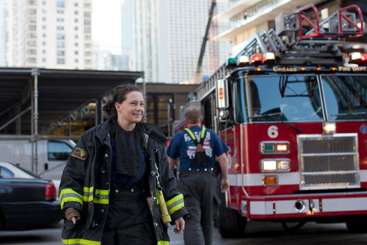 A Woman Firefighter Walks Near A Fire Engine In Chicago.