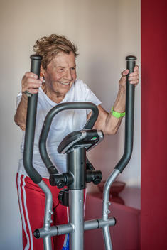 A very senior woman using an exercise machine