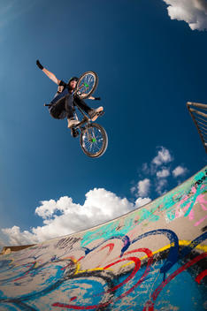 Germany, Young man performing stunt on BMX bike
