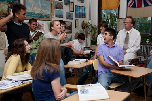 A Male Teacher And His Students Having A Lively Conversation