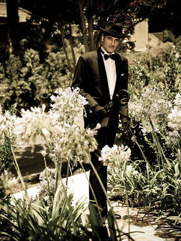 Portrait Of A Retro Looking Man Wearing A Tuxedo And Walking Through A Garden
