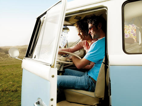 Happy Couple, African Descent, Sitting In Front Seat Of Camper Van.