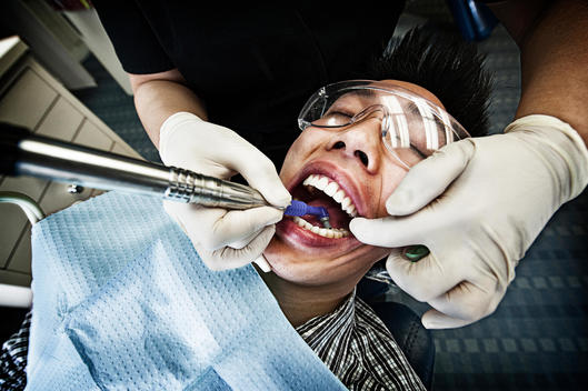 A Boy Getting His Teeth Cleaned At A Dentist\'S Office.