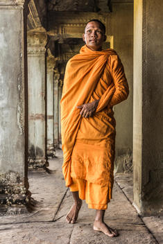 Young Buddhist monk walking through temple, Angkor Wat, Siem Reap, Cambodia