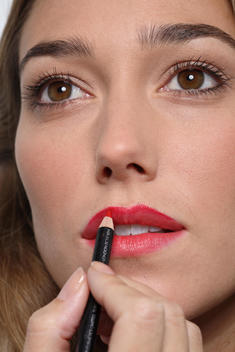 woman applying lipstick with pen