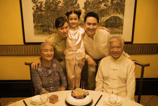 Three generation family during birthday party, smiling at camera, group portrait