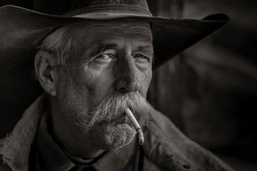 Portrait of an old cowboy smoking a cigarette