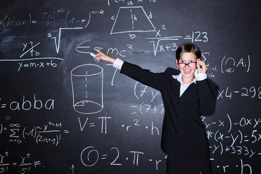Portrait of girl holding chalk and solving problems