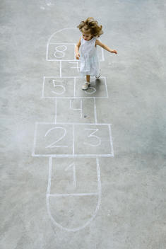 Little girl playing hopscotch, high angle view