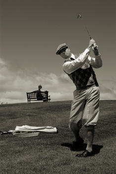 A middle aged man playing golf.