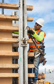 Hispanic worker holding hook at construction site