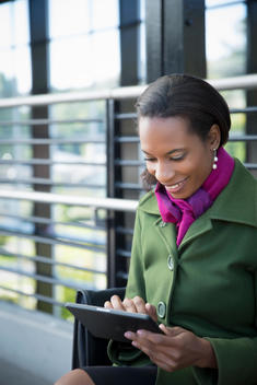 Black businesswoman using digital tablet on train platform