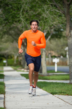 Caucasian man jogging on suburban street