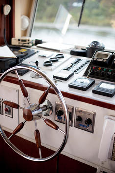 The steering wheel and controls inside of a boat or yacht.