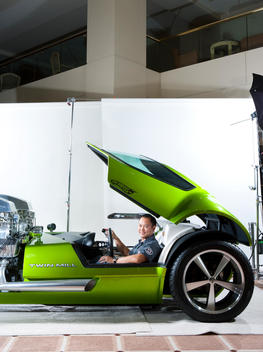 A designer for Mattel sits in the driver\'s seat of a life size, functional lime green Hot wheels car