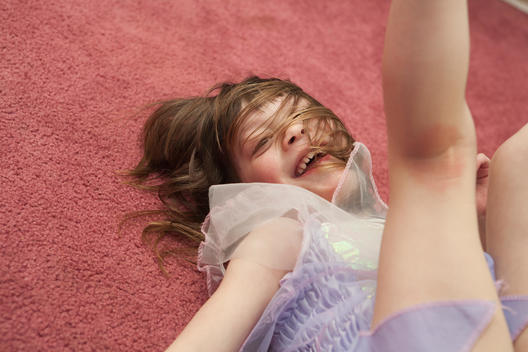 Young Girl Laying On Floor With Legs Up