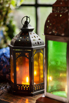 Lit candles inside of antique lanterns