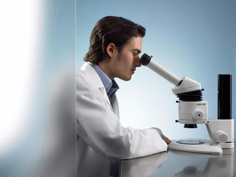 Lab Technician Looking Through Microscope