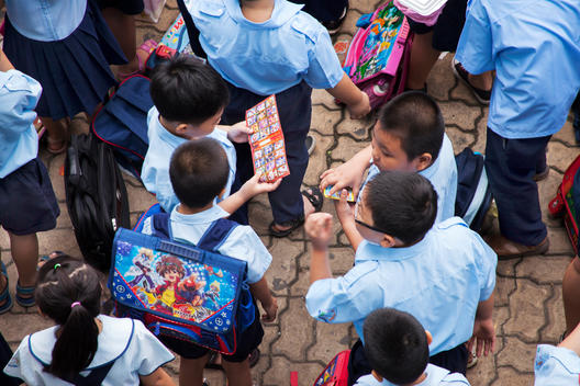 Students check-out a comic game while waiting for classes to start at their Saigon elementary school.