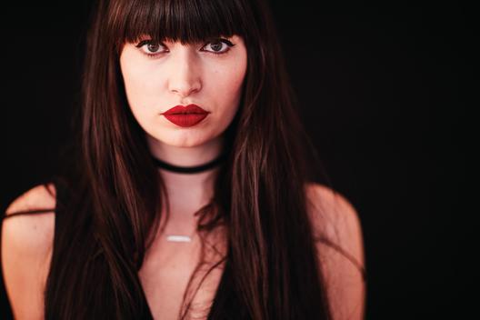 pale skinned brunette with red lipstick and bangs