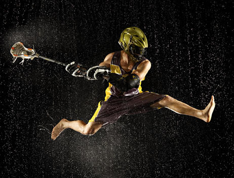 Lacrosse player jumping in the rain