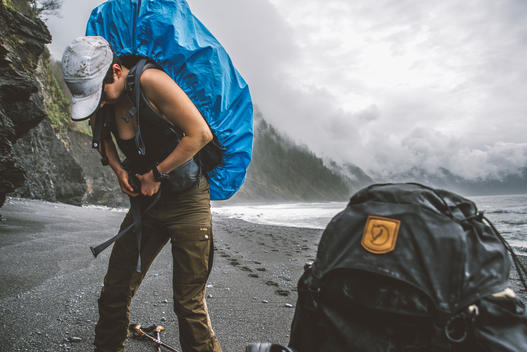 A female hiker puts on her pack and prepares to hike.