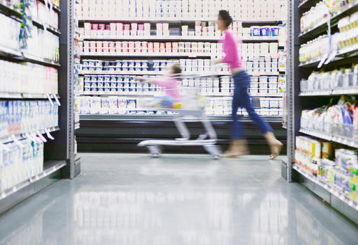 Blurred view of mother shopping in dairy aisle