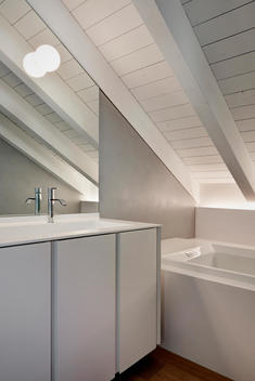 Wash basin and bath under beamed ceiling in Apartment Garegnani, Nerviano, Milan, Italy.