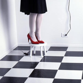 Woman\'s legs on stool in heels afraid of mouse