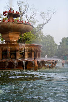 Indian children playing in water fountain.