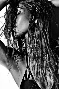 High contrast black and white shot of a girl in swimwear against a white wall