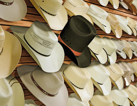 Top hat for sale among cowboy hats
