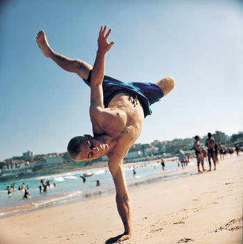 Man having fun at the beach while doing capoeira martial art