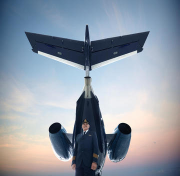 Caucasian pilot standing underneath airplane