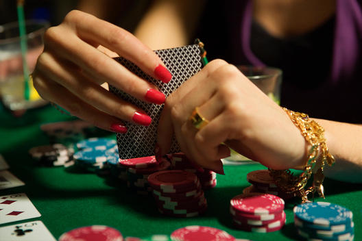 Poker Player With Gaudy Red Nails And Jewelry