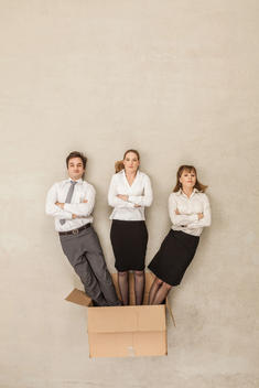 Business people coming out of cardboard box