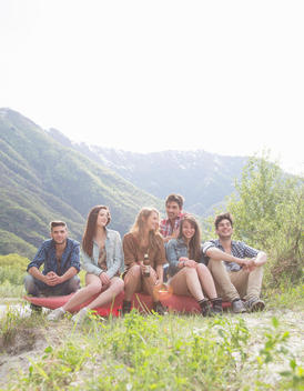 Group of six young adult friends sitting on canoe, Piemonte, Italy