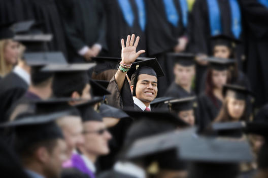 College graduate waving