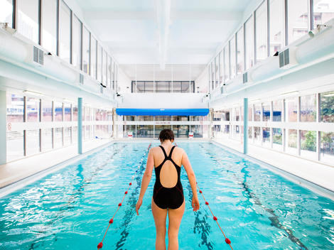 Woman preparing to dive at Golden Lane Leisure Centre design renovation by Cartwright Pickard Architects, original design by Chamberlin Powell and Bon in 1952, Barbican, London, UK.