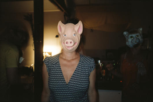 A woman with a pig mask in a party.