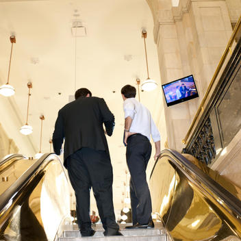 Men Entering Store Via Escalator