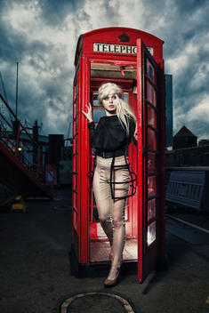 lady in front of an english telephone cell on harbor in Hamburg