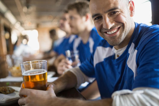 Portrait of sports fan drinking beer in pub